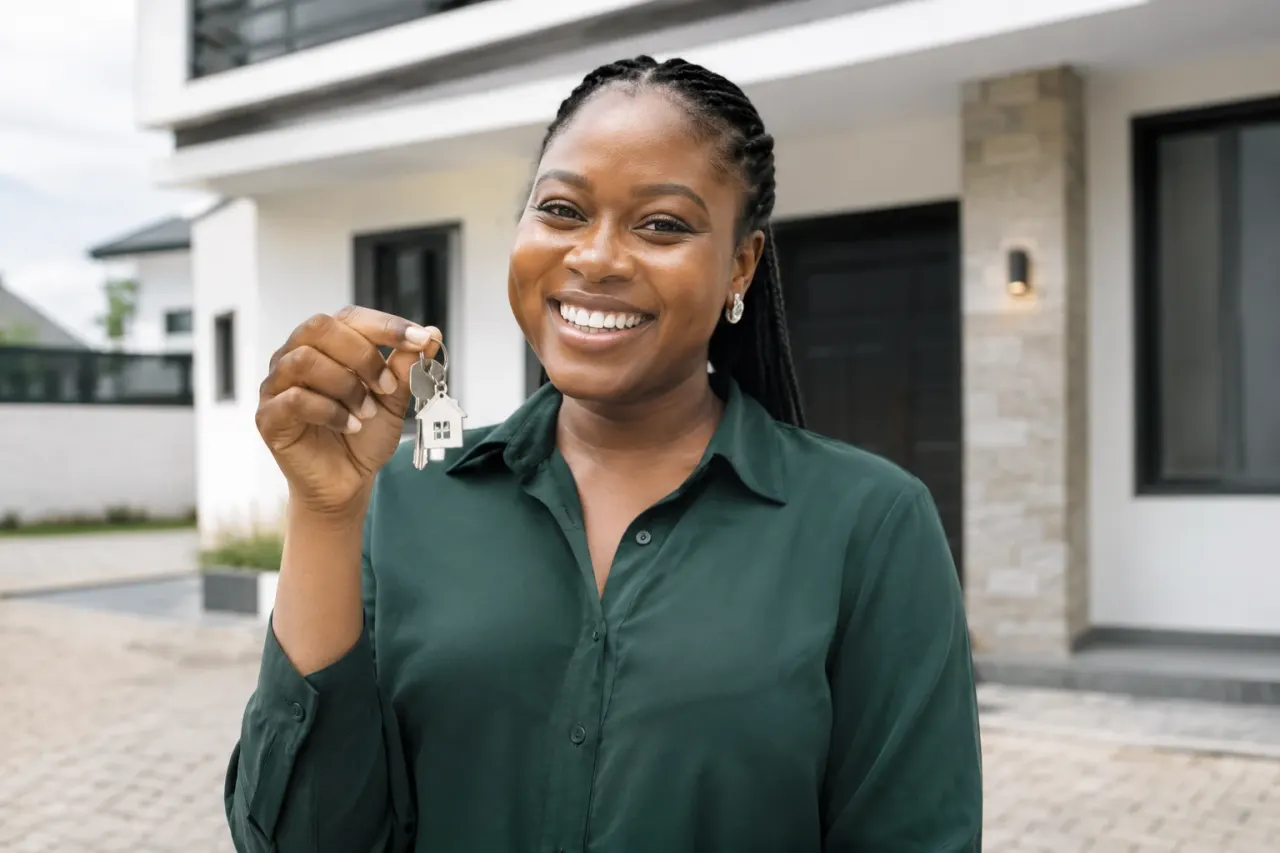 Smiling new homeowner holding up house keys